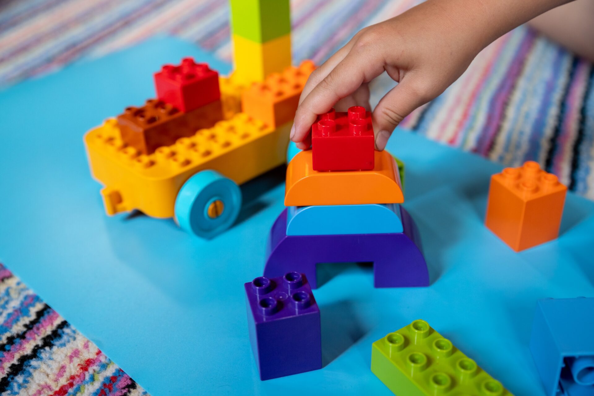 close up of hands playing with duplo blocks