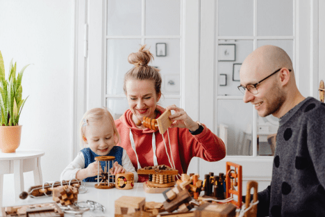 a family is playing with wooden toys at home