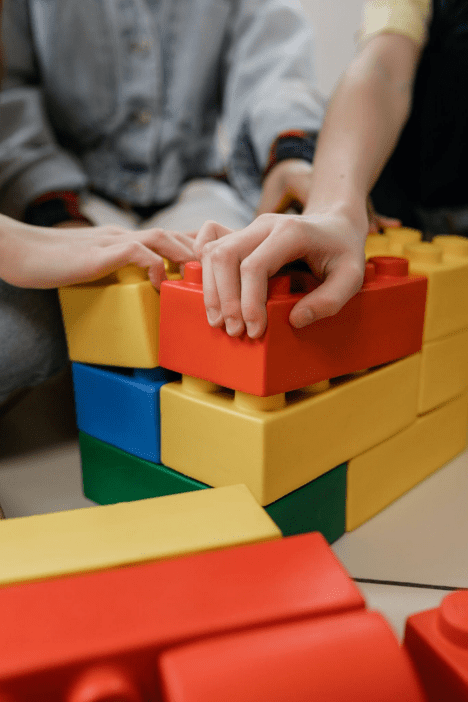 close up of hands playing with large blocks